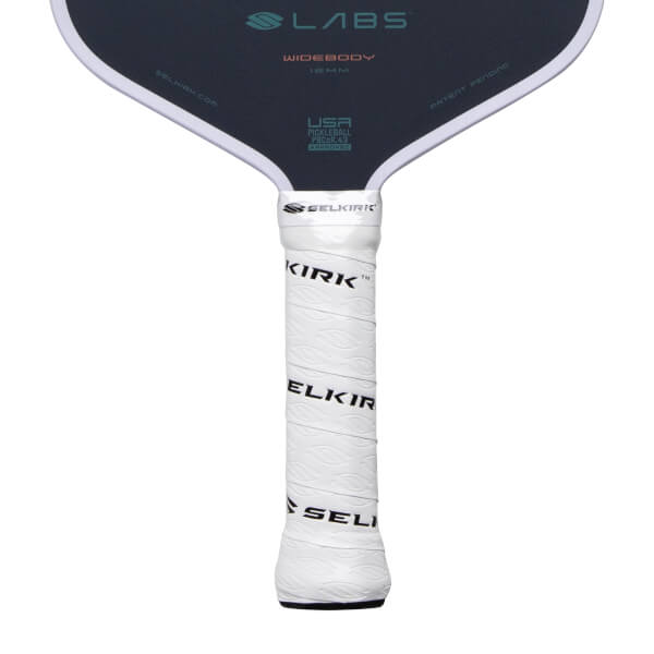Close-up of a dark gray pickleball paddle with a white textured grip showing SELKIRK branding and LABS WIDEBODY on the face.