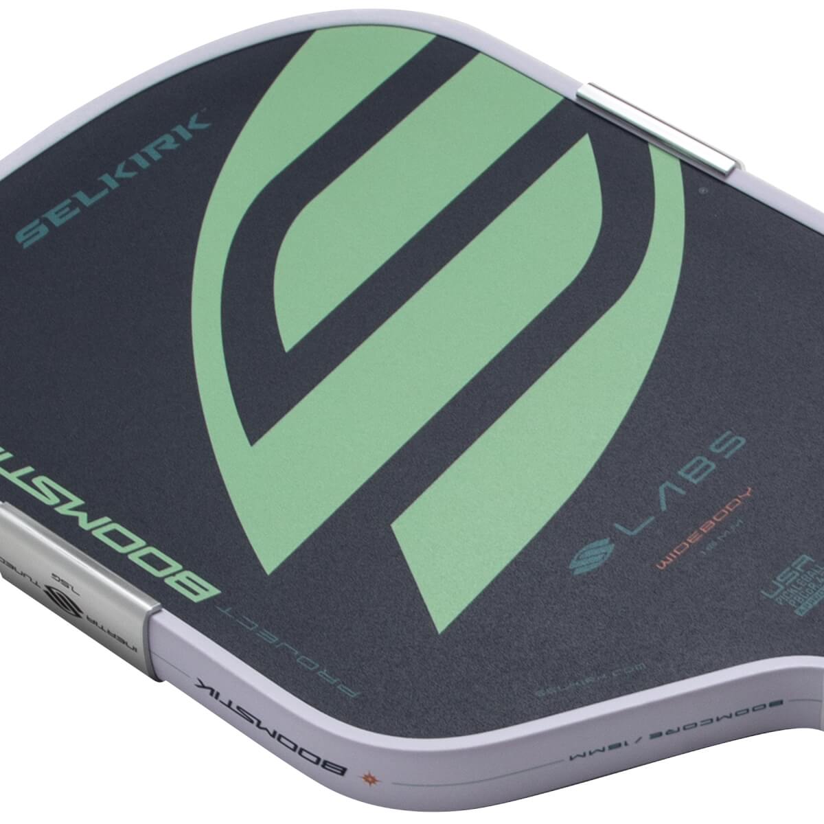 Angled close-up of a dark gray and light green pickleball paddle with a large abstract graphic, SELKIRK text, and white edge guard.