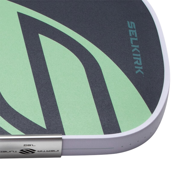 Close-up of a dark gray pickleball paddle with mint green wavy design, SELKIRK text, and a white edge guard.