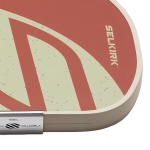Corner view of a paddle with a red and cream design, showing the "SELKIRK" logo and "7.5G INERTIA" text.