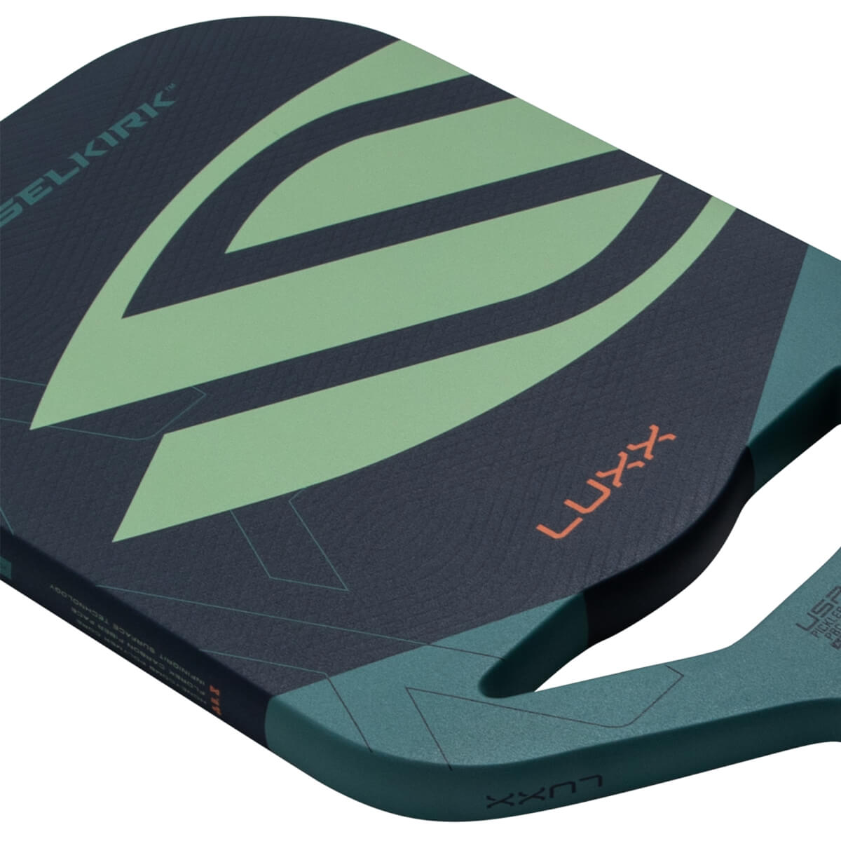 Angled close-up of a dark blue pickleball paddle with a light green design, SELKIRK and LUXX text, and a teal handle.