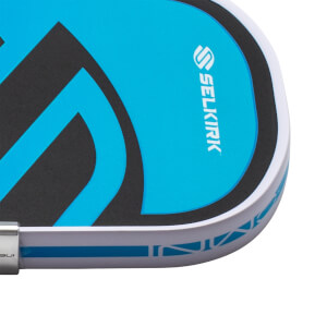 Close-up of a pickleball paddle corner showing the "SELKIRK" logo and a blue graphic design.