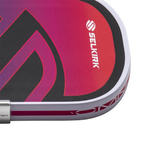 Corner view of a pickleball paddle with a pink and purple gradient, the SELKIRK logo, and a white edge band.