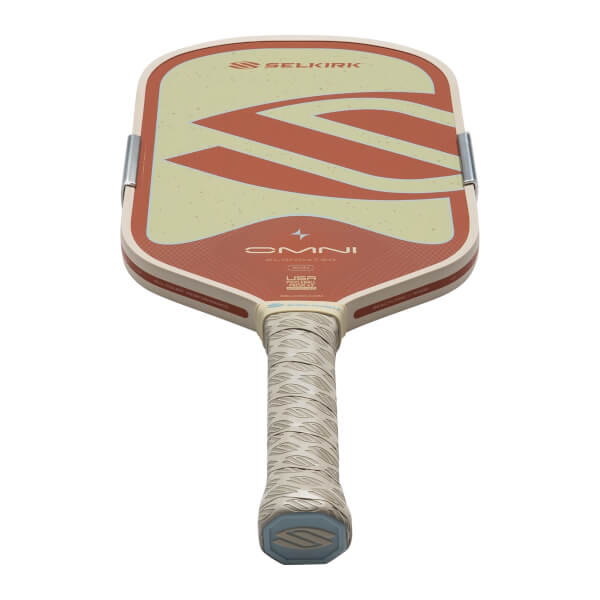 Top-down view of a Selkirk OMNI pickleball paddle with a beige and red design, featuring the Selkirk logo.