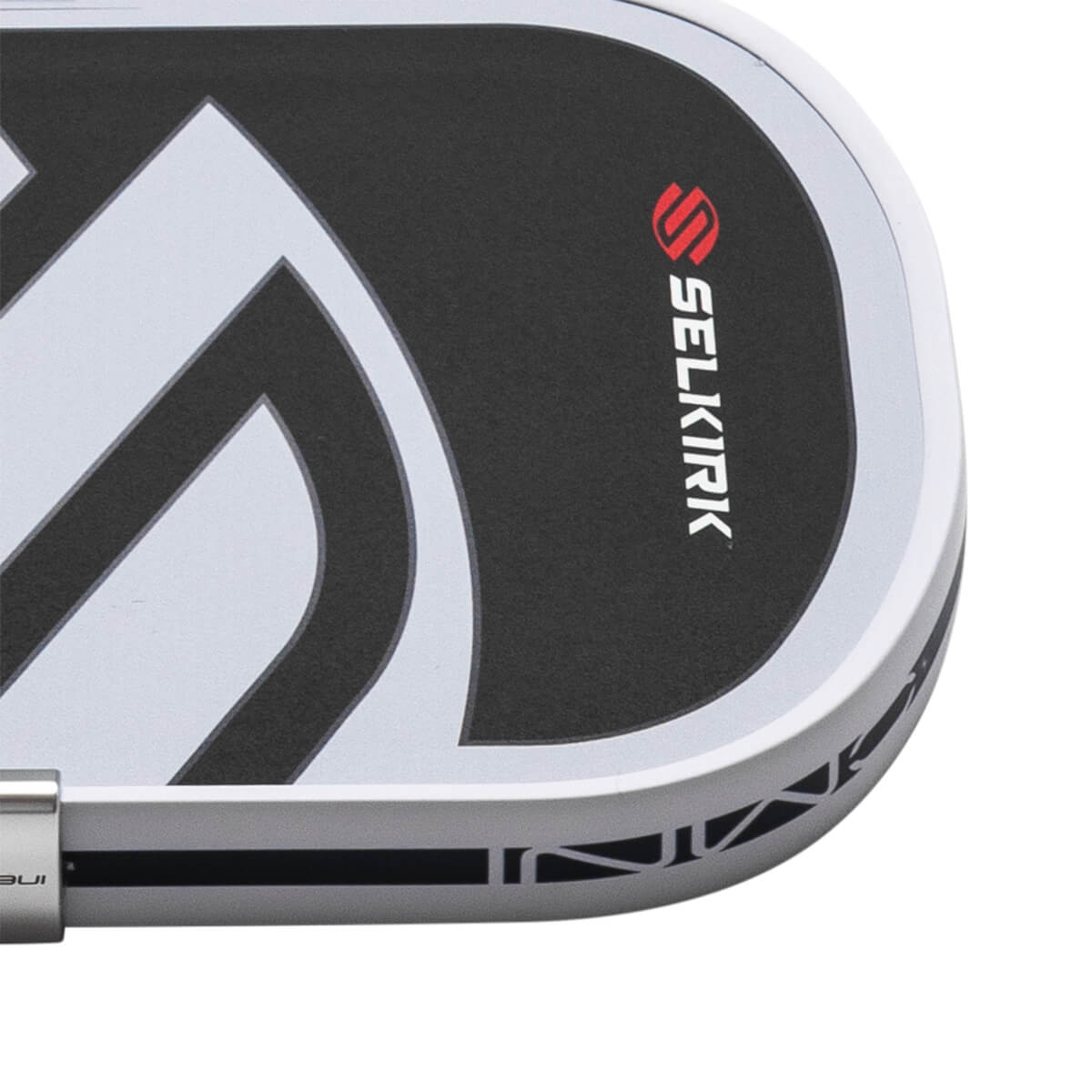 Close-up of the Selkirk logo on a black surface with white graphic accents and a silver edge.