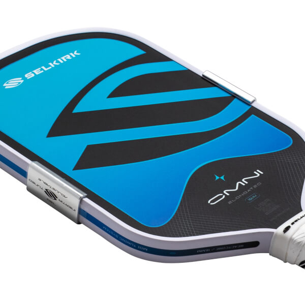 Close-up of the top corner of a pickleball paddle showing the Selkirk logo, blue and black design, and "OMNI ELONGATED 16MM" text.
