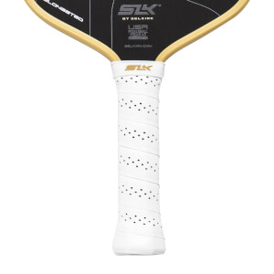 Close-up of a white pickleball paddle handle with a perforated grip and black paddle face with gold SLK branding.