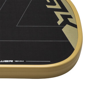 Close-up of a black pickleball paddles bottom right corner with gold SLK branding, white lines, and a gold edge guard.