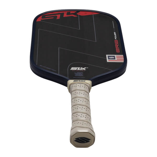 Top-down view of a black pickleball paddle with red "SK" logo and an American flag detail.