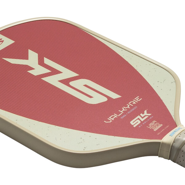 Corner view of a pickleball paddle with a red textured surface, a cream-colored border, and "SLK" and "VALKYRIE" text.