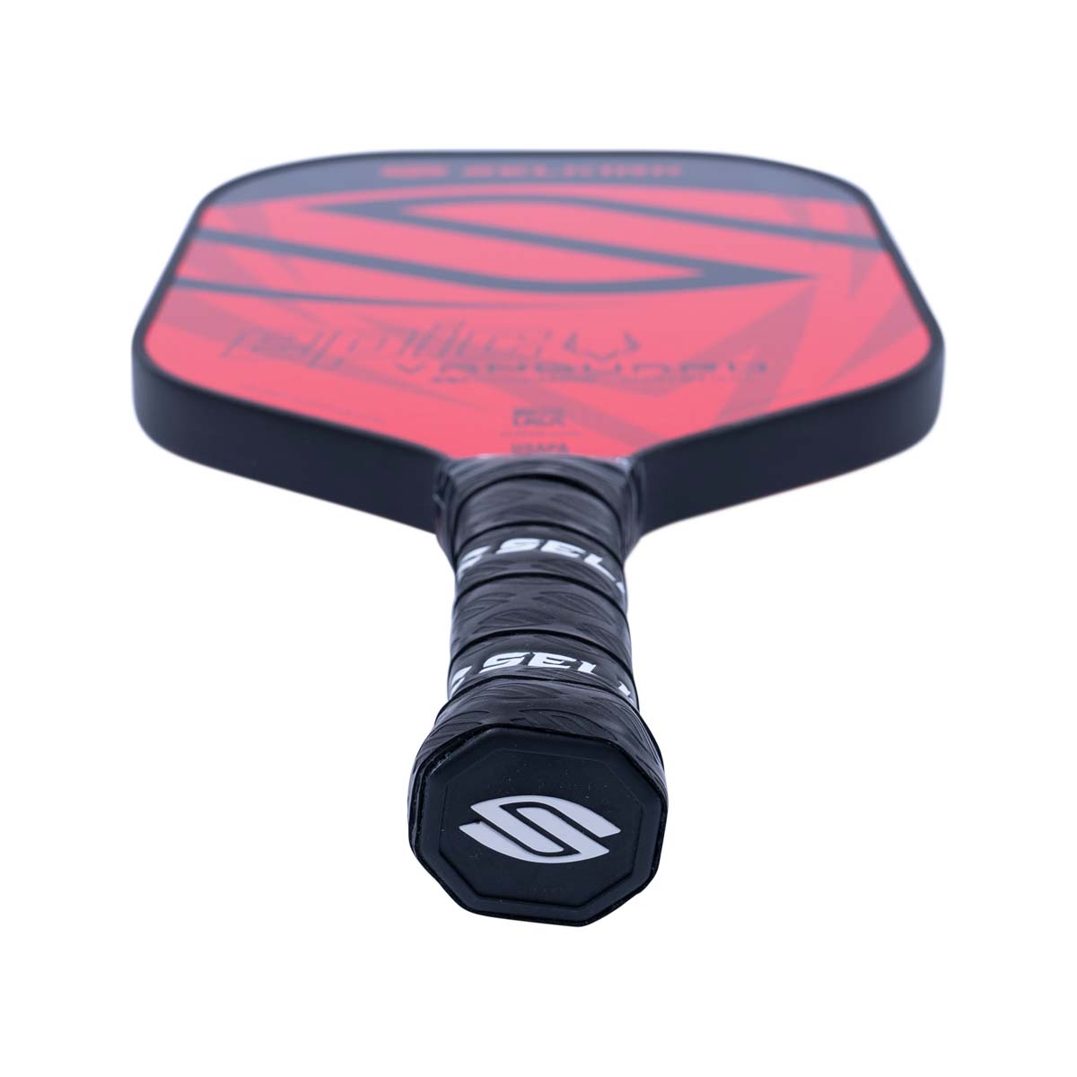 Top-down view of a red pickleball paddle with black geometric accents and a black grip with Selkirk branding.