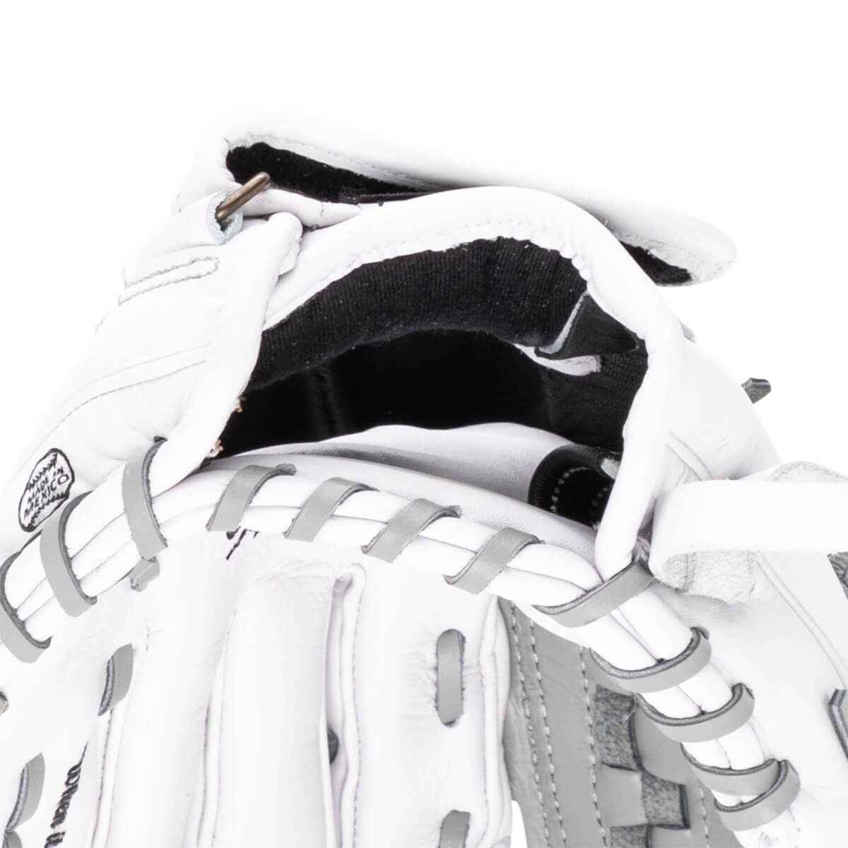 Close-up of a white baseball glove showing the "MADE IN MEXICO" stamp and grey lacing.