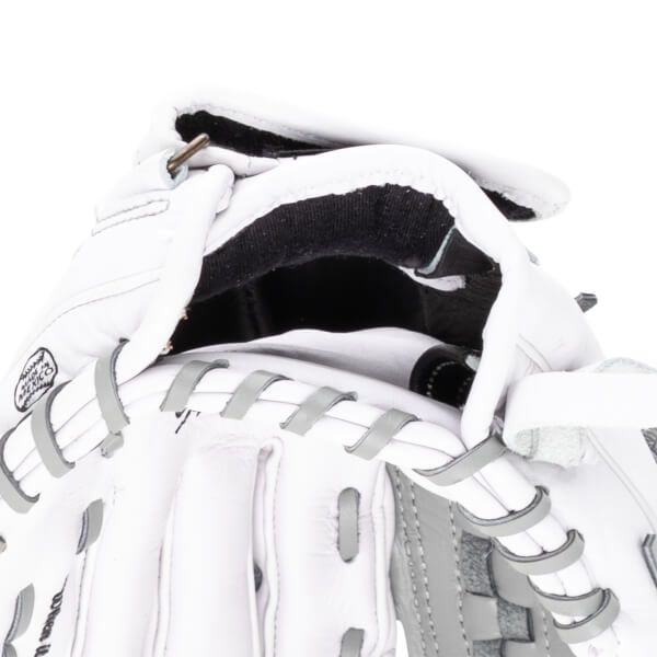Close-up of a white baseball glove showing the "MADE IN MEXICO" stamp and grey lacing.