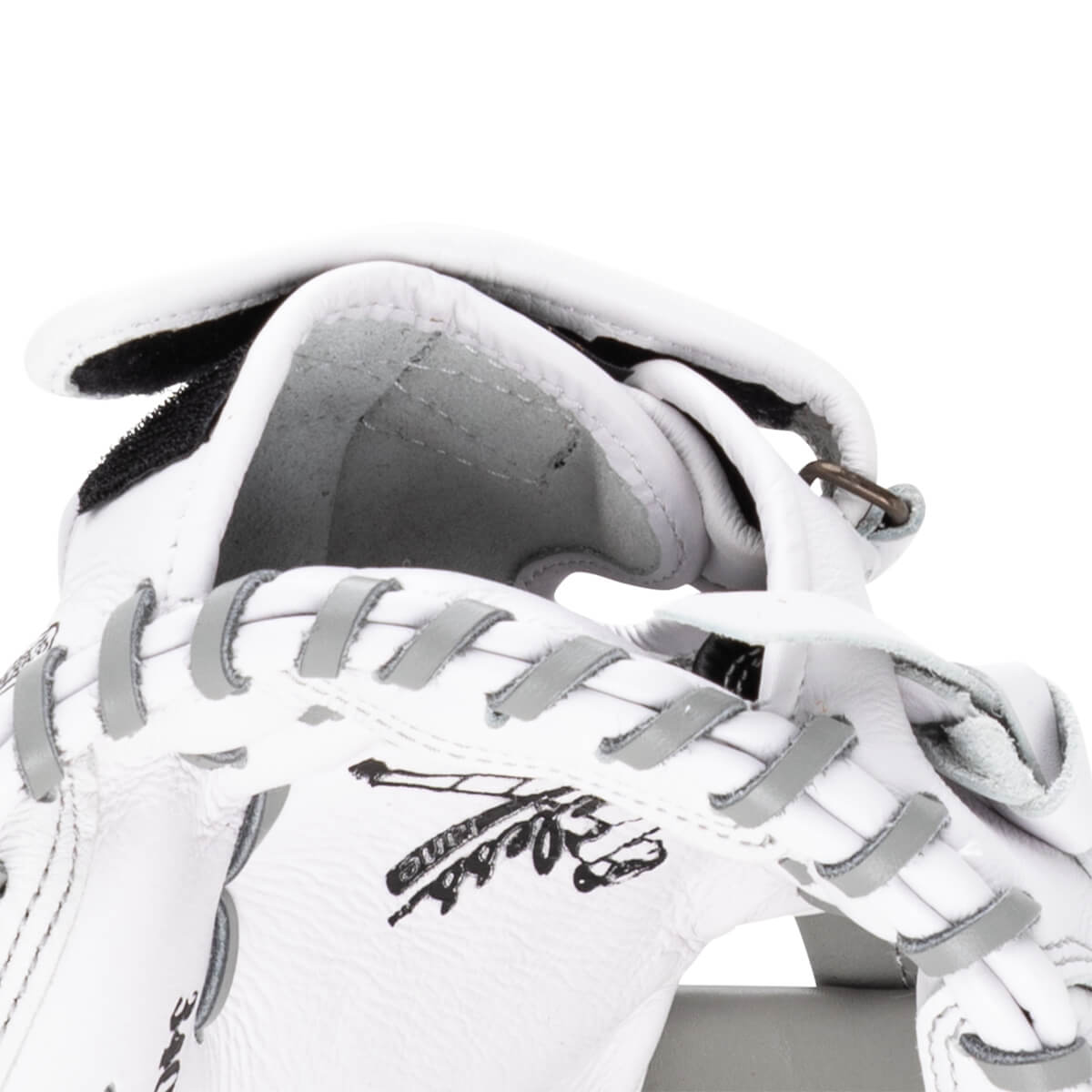 Close-up of a white baseball glove showing grey lacing and a black logo.