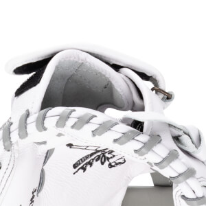 Close-up of a white baseball glove showing grey lacing and a black logo.