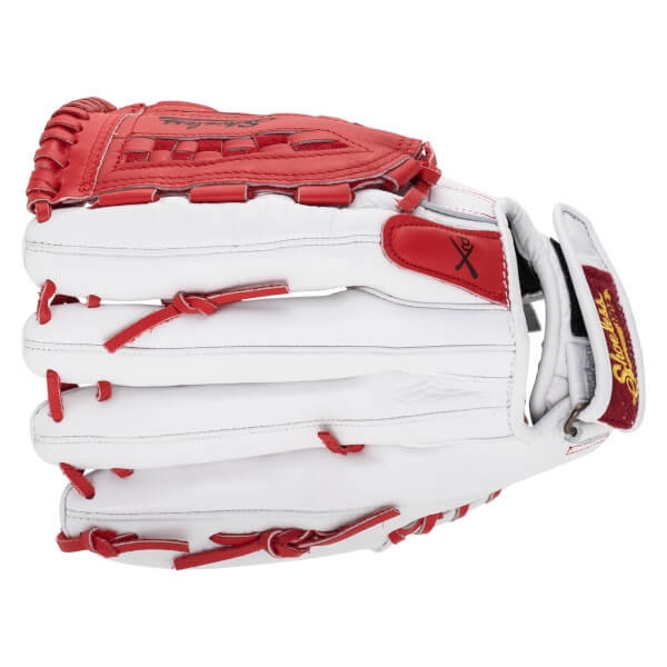 Close-up view of a white fastpitch softball glove with red lacing and details, showing "Shoeless" text.