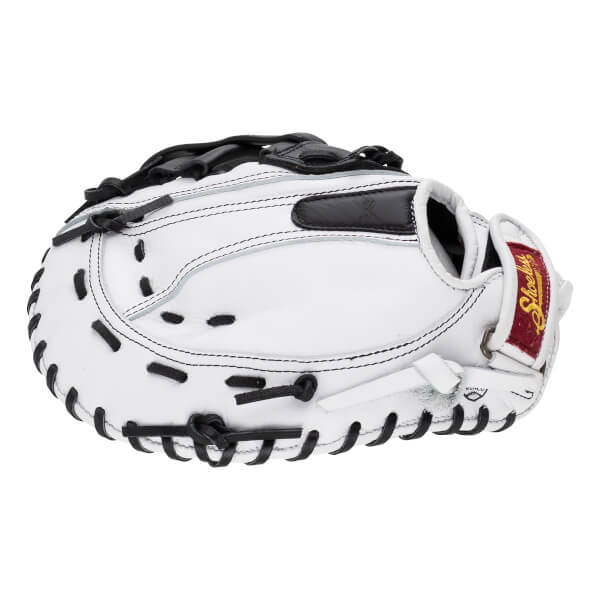 Back view of the white leather softball mitt featuring black laces and a red wrist strap with the "Shoeless" logo in gold script.