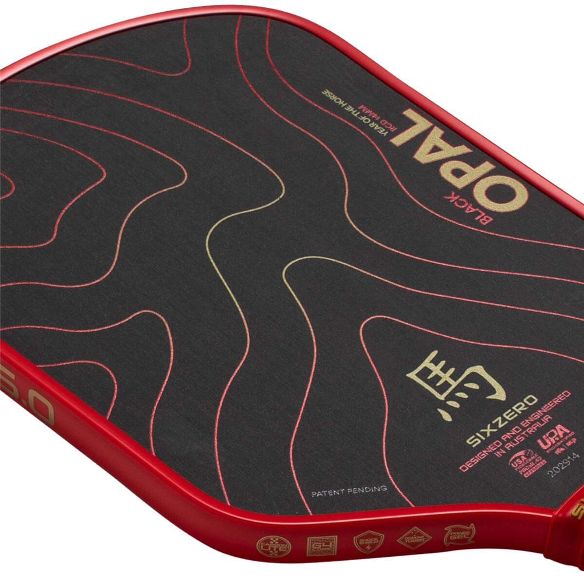 Angled close-up of a black pickleball paddle with a red edge, gold BLACK OPAL and Chinese horse character.