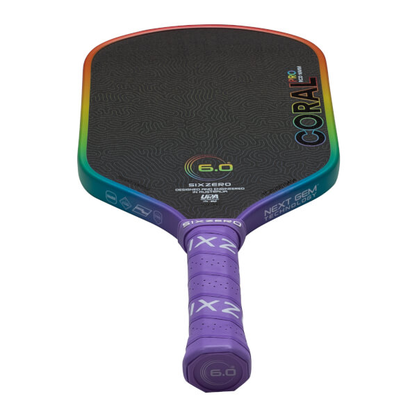 Front view of a Six Zero Coral paddle with a rainbow edge, showing "CORAL PRO" and "NEXT GEM TECHNOLOGY".