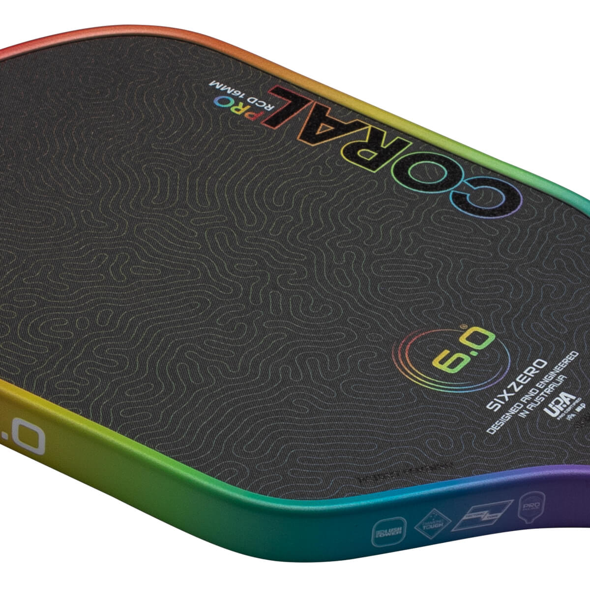 Corner view of a black surfboard with a rainbow-colored edge, featuring "CORAL PRO" text and a "6.0" graphic.