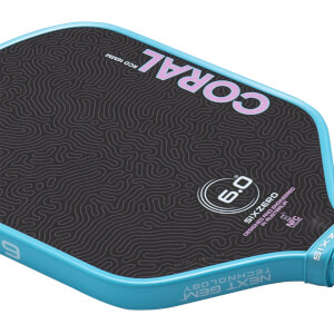 Angled close-up of the Coral 6.0 pickleball paddle showing pink topographic patterns on a black face and a light blue rim with Next Gen Technology text.