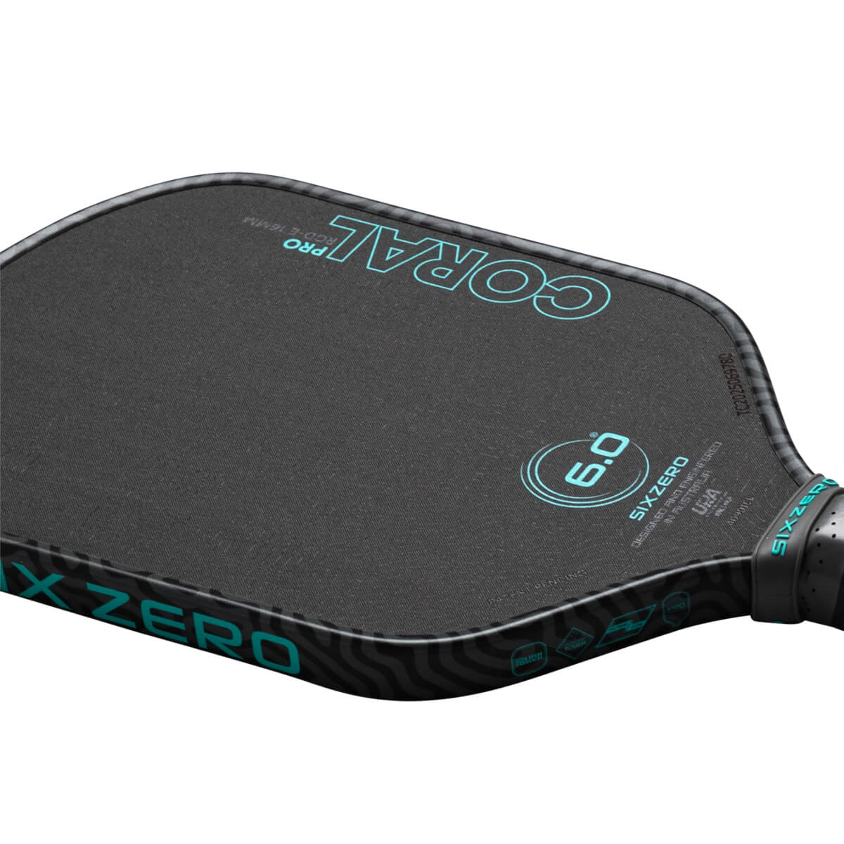 Corner view of a black pickleball paddle with "CORAL PRO" and "SIX ZERO" in teal.