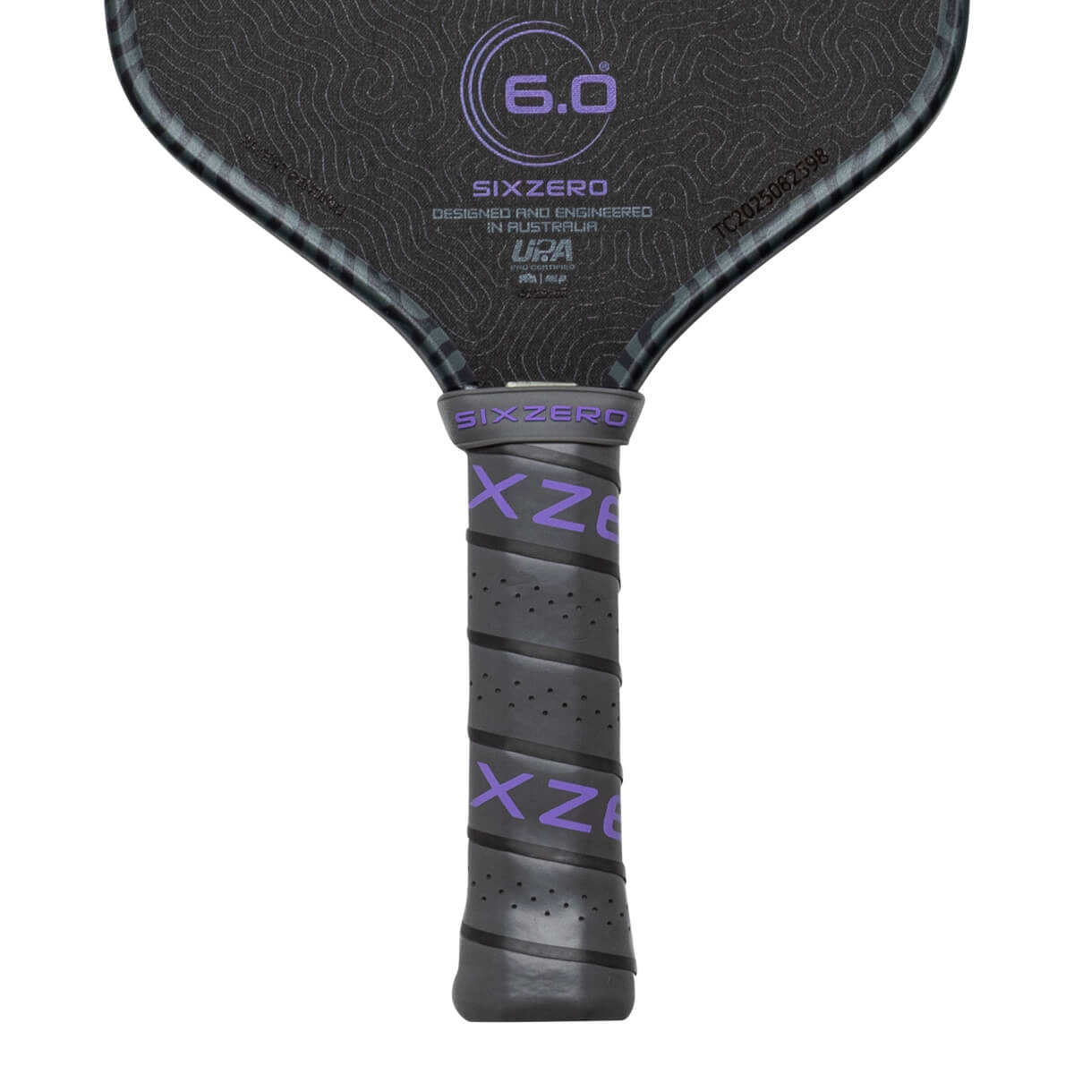 Close-up of a pickleball paddle grip showing purple "SIXZERO" text and a textured surface.