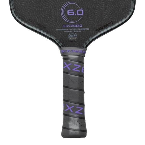 Top-down view of a pickleball paddle showing the "SIXZERO" logo, "6.0" in a circle, and a textured grip with purple "XZ" lettering.