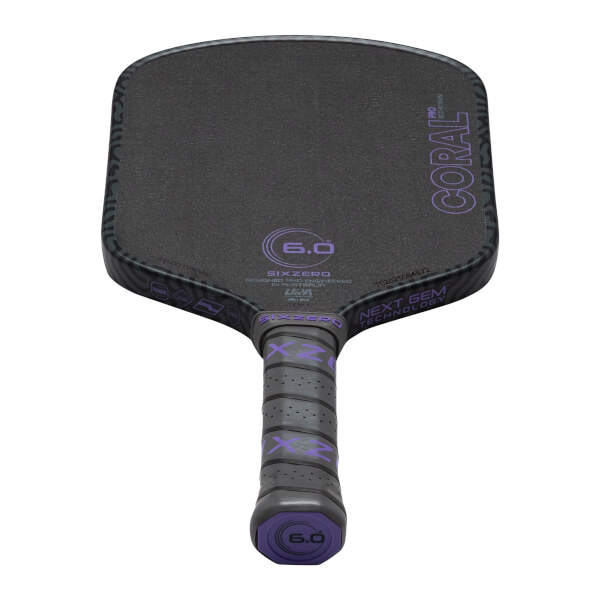 Top-down view of a black pickleball paddle with purple "CORAL PRO" text, "SIXZERO" logo, and "6.0" markings.