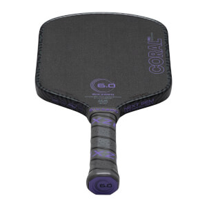 Top-down view of a black pickleball paddle with purple "CORAL PRO" text, "SIXZERO" logo, and "6.0" markings.