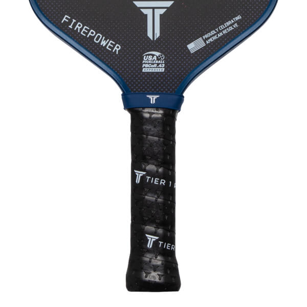 Close-up of a pickleball paddle grip showing "TIER 1" text and a textured pattern.