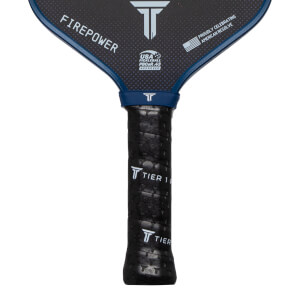 Close-up of a pickleball paddle grip showing "TIER 1" text and a textured pattern.