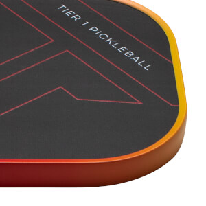 Corner view of a black pickleball paddle with red geometric lines and "TIER 1 PICKLEBALL" text.