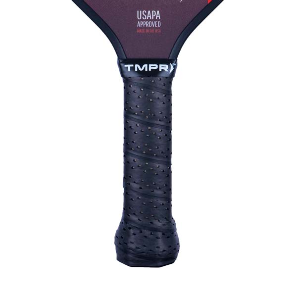 Close-up of a black pickleball paddle grip with perforations and the TMPR logo.