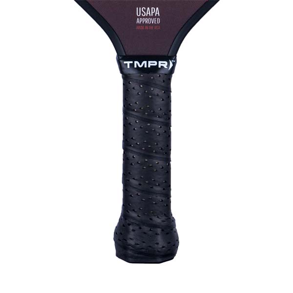 Close-up of a black pickleball paddle grip with perforated texture and TMPR branding.