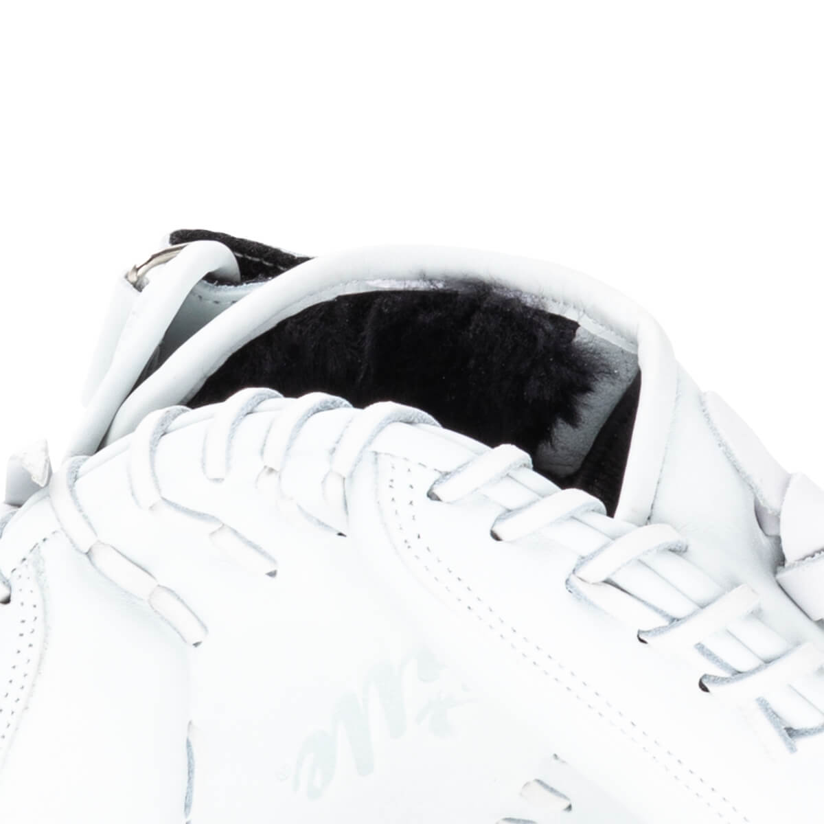 Close-up of a white leather sneaker showing black fur lining, white laces, and the word "Title" in script.