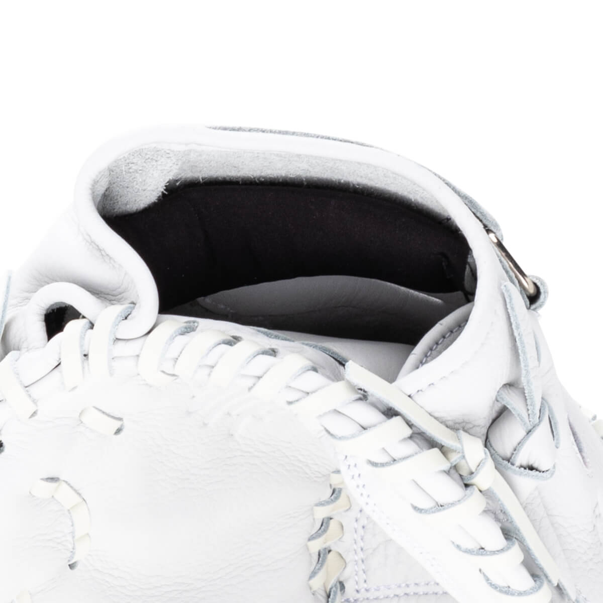 Close-up of the interior of a white baseball glove showing the pocket and lacing.