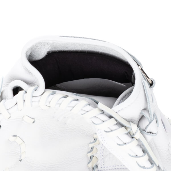 Close-up of the interior of a white baseball glove showing the pocket and lacing.