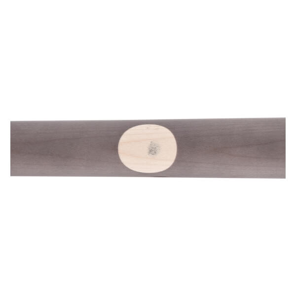 Close-up of a dark gray maple wood baseball bat featuring a light oval ink dot.