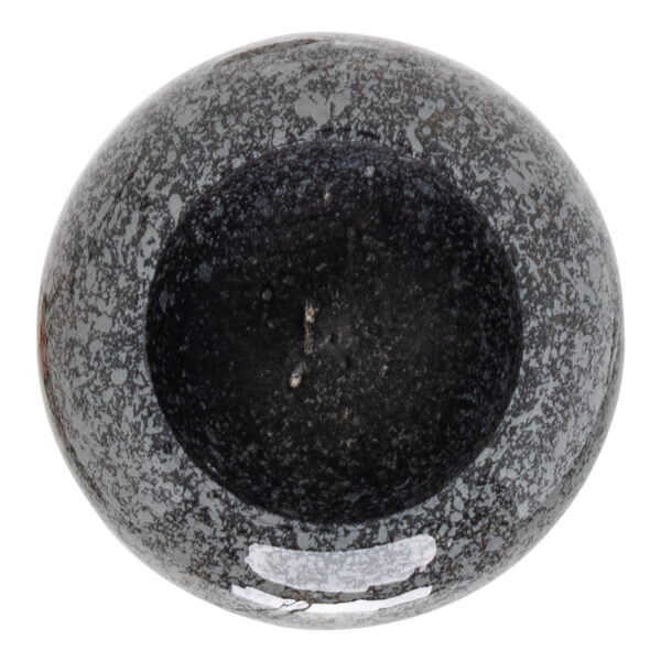 Top-down view of a speckled gray and black mortar with a dark, granular interior.