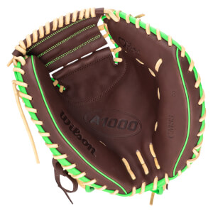 Top-down view of a brown baseball glove with bright green lacing and tan stitching, showing "Wilson A1000" and "CM33".