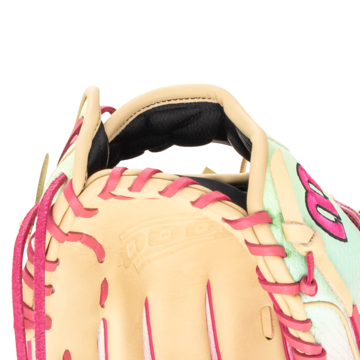 Close-up view of a baseball glove's wrist strap and lacing, featuring pink lacing and a light green patterned material.