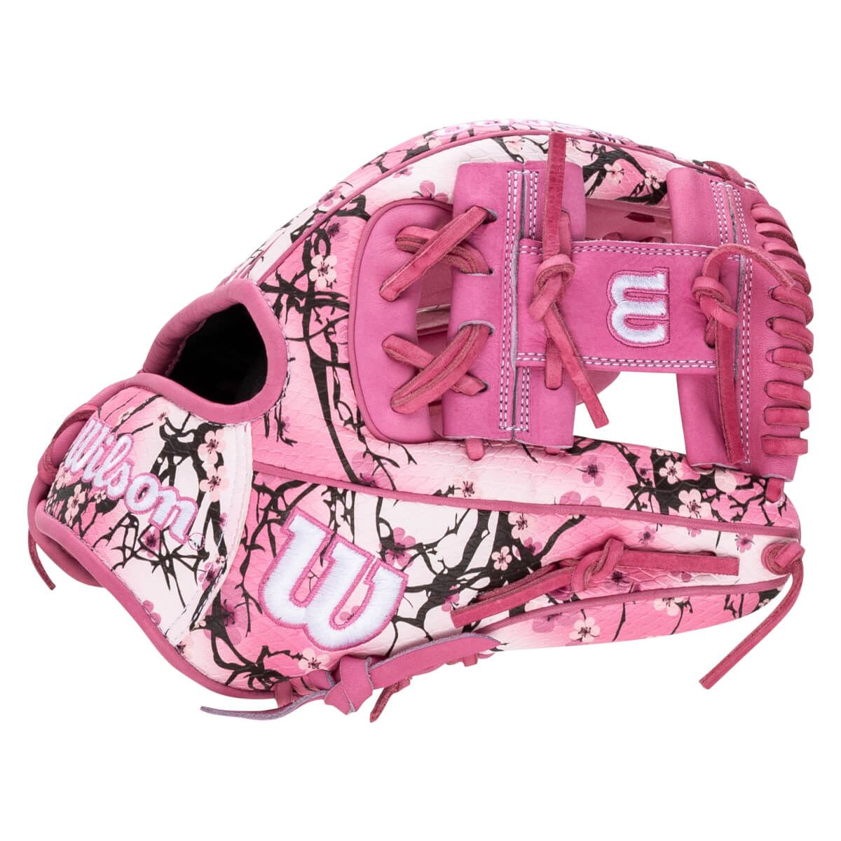Exterior side view of a pink glove with a black cherry blossom pattern and white "W" and "Wilson" logos.