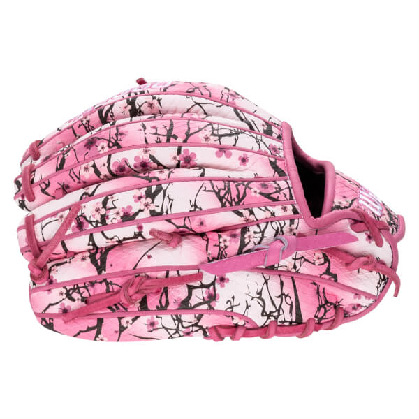 Back view of a baseball glove featuring a pink and white cherry blossom pattern with black branches, pink laces, and a white "W" logo on the thumb.