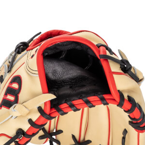 Close-up of a tan baseball glove with red binding and black lacing, showing the "W" logo.