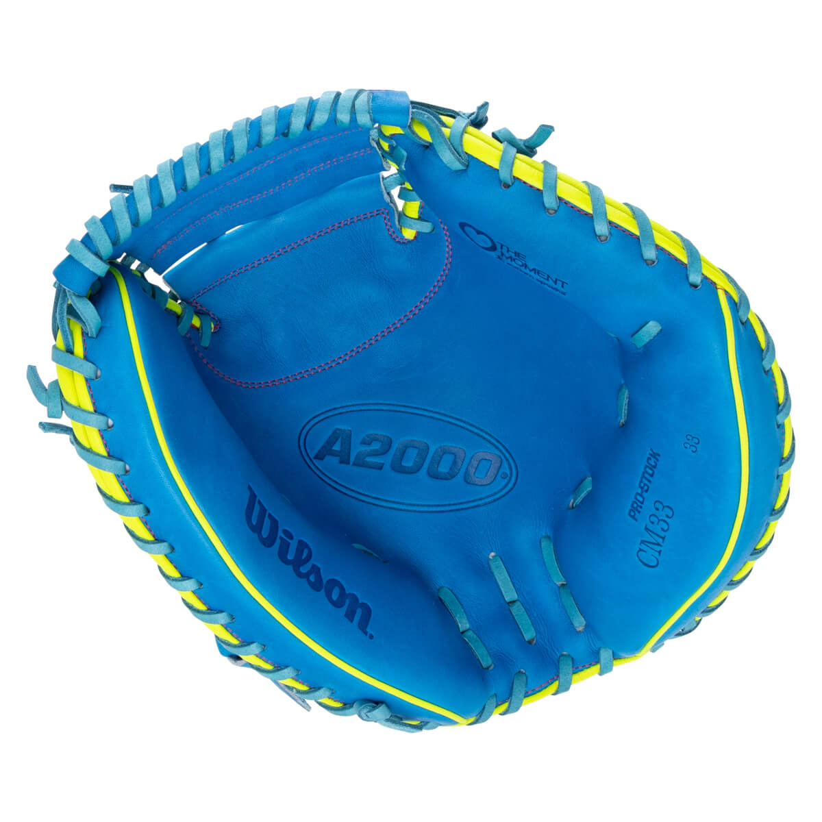 Front view of the inside pocket of a blue Wilson catcher's mitt with neon yellow trim, featuring prominent "Wilson", "A2000", and "CM33 Love The Moment" branding.