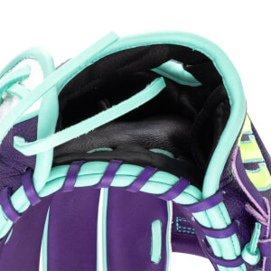 Close-up of a purple baseball glove with aqua lacing and a black interior.