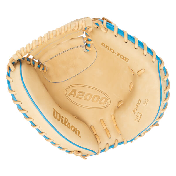 Top-down view of a tan baseball glove with blue lacing, showing "Wilson", "A2000", and "PRO-STOCK M23 33.5" text.