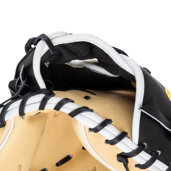 Close-up of a black and white baseball glove, showing tan leather interior and black lacing.