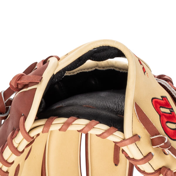 Close-up of a tan baseball glove showing the pocket, brown lacing, and a red embroidered "B".